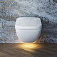 L'image montre des toilettes modernes suspendues devant un mur à l'aspect marbré frappant et une lumière chaude au sol, ce qui confère à la pièce une atmosphère stylée et élégante.