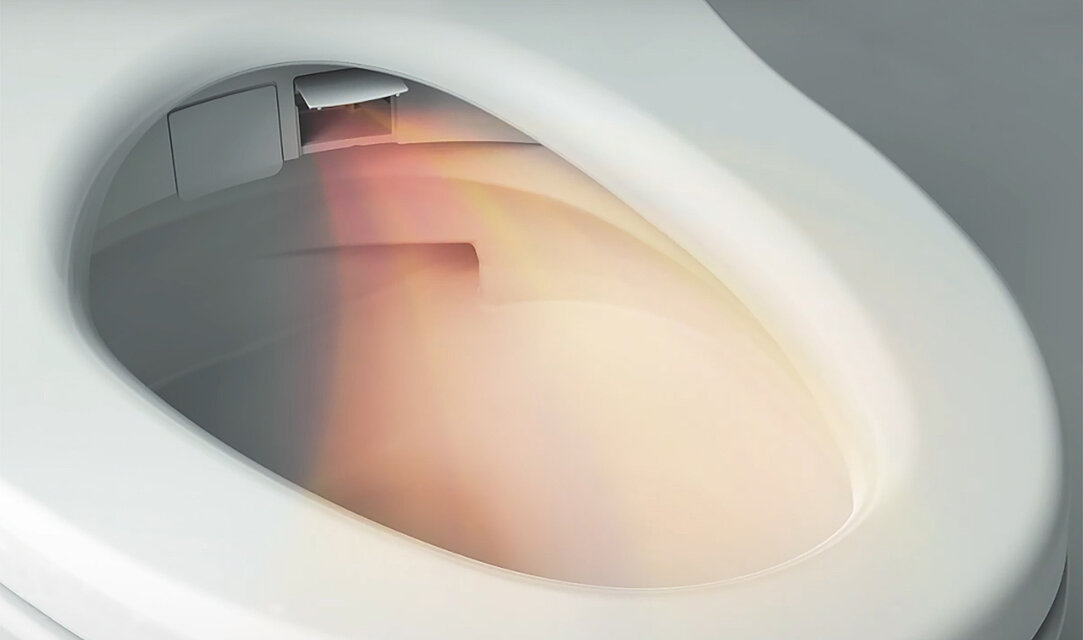 L'image montre un Washlet, le clapet à droite de la buse est ouvert. Un jet d'air en sort, il est courbé et coloré en orange/rouge.