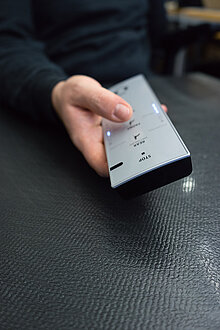 A hand holds a remote control for a WASHLET®.